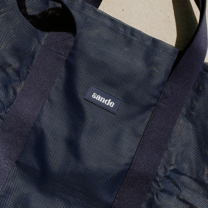 Sande logo on from of beach bag.
