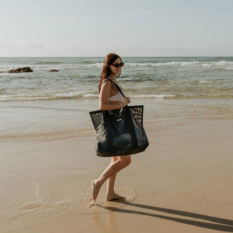 Girl on beach with beach bag by Sande Kids. Mesh and generous in size.