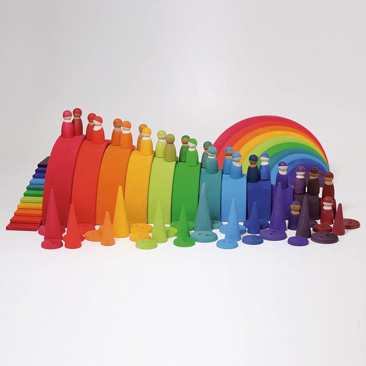 Grimms colourful wooden figures arranged in a rainbow pattern with a rainbow arch on a white background.