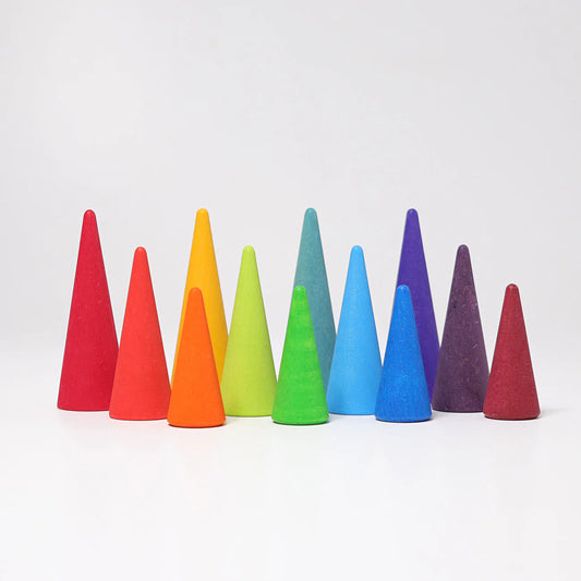 Grimms colourful wooden cones arranged in a row on a white background
