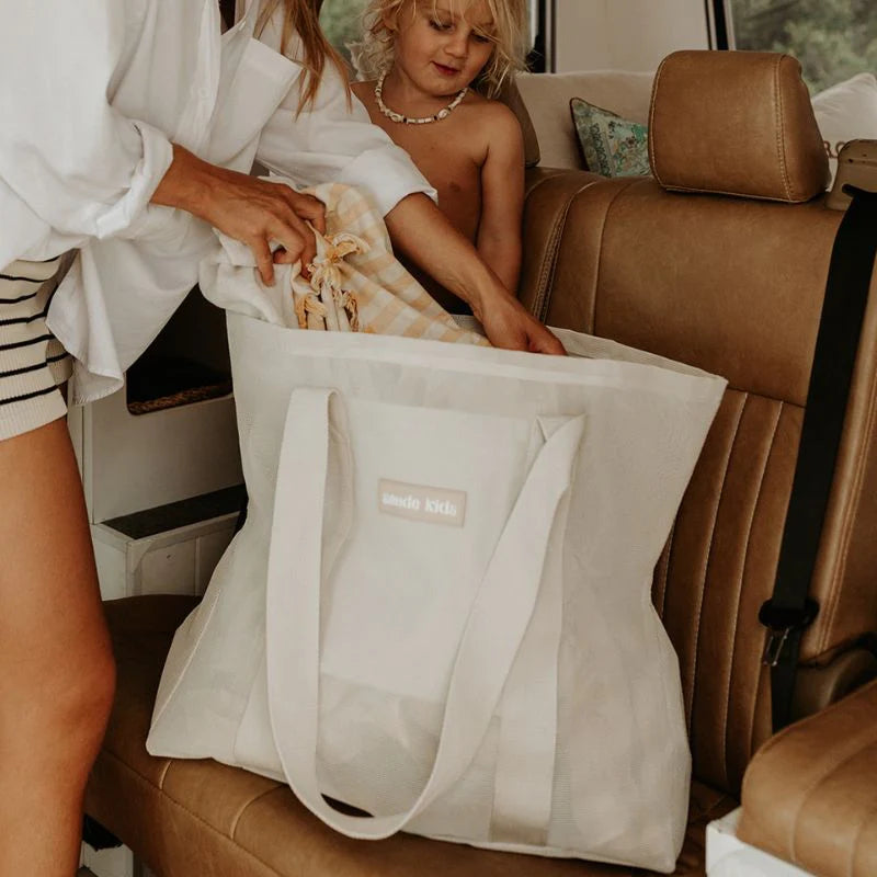 Sande Kids Sand Beach bag mini on back seat of van getting packed by mum and toddler.