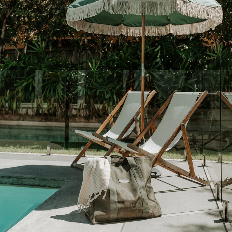 Styled shot of Sande Kids Beach Bag mini in Pandanus by the pool.