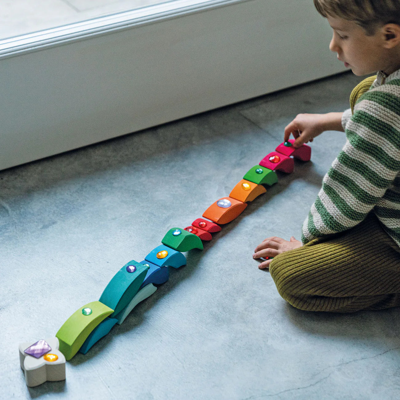 Grimm's Building Set Lara with 73 colourful curved wooden blocks for imaginative building and open-ended play.