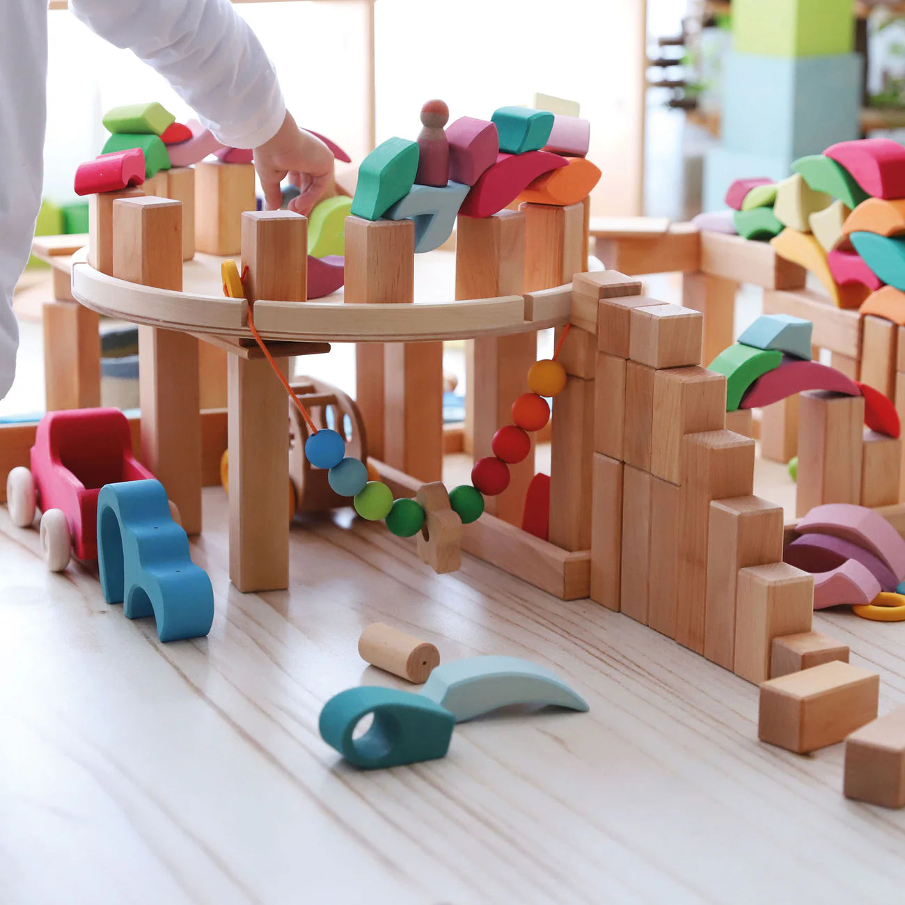 Grimm's Building Set Lara with 73 colourful curved wooden blocks for imaginative building and open-ended play.