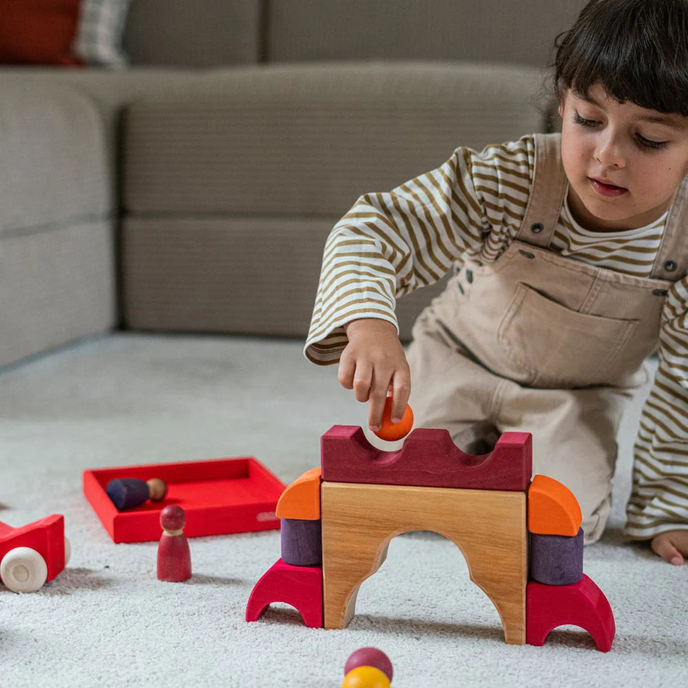 Grimm's Red Building Set with large red wooden blocks for creative building and open-ended imaginative play.